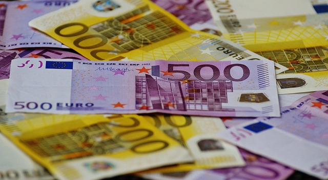 monety euro i banknoty na tle mapy Unii Europejskiej